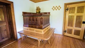 A room with a wooden bench, a wooden door, and a wall-mounted decorative item.