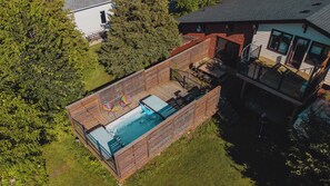 Ein Garten mit Whirlpool, Holzterrasse und kleiner Terrasse.