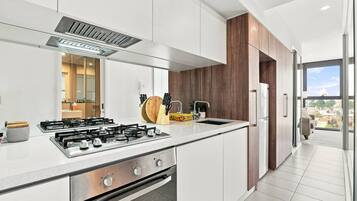 Una cocina moderna con estufa a gas, electrodomésticos de acero inoxidable y vistas al exterior.