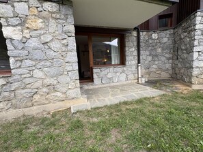 A stone building with a covered patio area and a grassy lawn. - 100m from ski lifts, Ground floor, terrace, tv, ski locker, 30m², Valmorel (Valmorel)