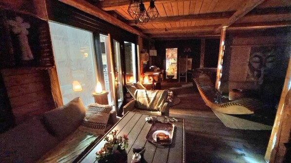 A cozy room with a sofa, a dining table with a tray, and a staircase.