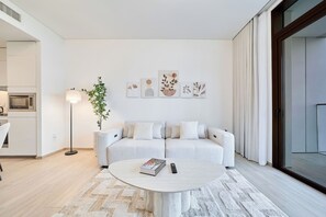 Un salon moderne avec un canapé, une table basse et un lampadaire.