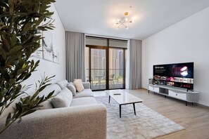 A modern living room with a sofa, coffee table, and a flat-screen TV. - Chic 1BR Escape in Palace Residences | Creek (Dubai)