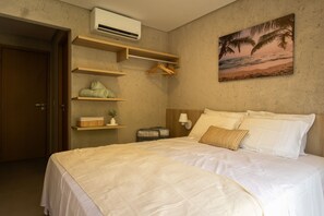 A hotel room with a bed, a wall-mounted air conditioner, a painting of a beach, and a wooden door. - Villa Anahi 2-bedroom Apt Private Pool by MME (Passo de Camaragibe)