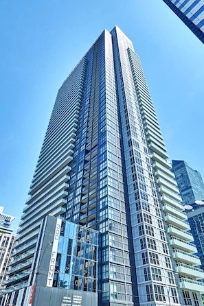 A tall, modern skyscraper with a glass facade and a prominent vertical line marking the 300th floor. - New · Monthly 1BR Condo by CN Tower & PATH (Toronto)