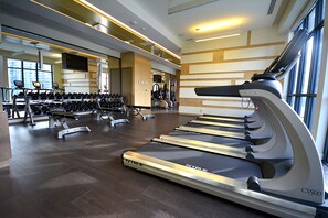 A modern gym with treadmills, dumbbells, and weight machines. - New · Monthly 1BR Condo by CN Tower & PATH (Toronto)
