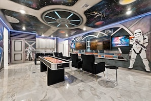 A room with a pool table, gaming chairs, a large TV, and Star Wars-themed decorations. - Paradiso Grande 15br Suites, Pool & Themed Rooms (Orlando)