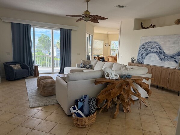 A spacious living room with a sofa, a coffee table, and a dining area. - Salty Serenity | Your Hernando Beach Escape (Hernando Beach)