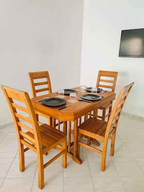 A dining table with four wooden chairs, black plates, and clear glasses. - Tranquil 2-bedroom apartment in vibrant Casablanca neighborhood (Casablanca)