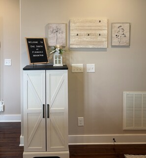 A reception area with a white cabinet, a welcome sign, and three framed artworks on the wall. - New Listing: Modern Mountain Farmhouse with Views (Union Mills)