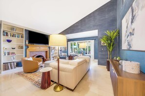 Ein modernes Wohnzimmer mit Kamin, Sofa und Bücherregalen.