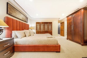 Ein Schlafzimmer mit einem großen Bett, einem Kleiderschrank, einem Schreibtisch und einem Wandbild.