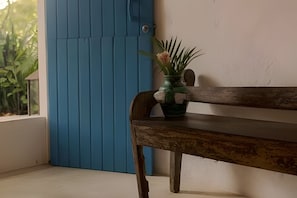 Eine hölzerne Bank mit einem Blumentopf neben einer blauen Tür.