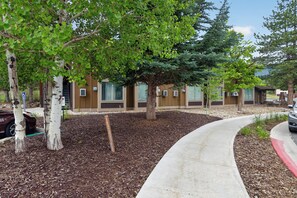 A pathway leading to a building with a modern design, surrounded by trees and a landscaped area with mulch. - Romantic Retreat - 4 Min to Skiing (Park City)