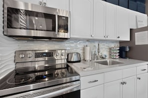A modern kitchen with stainless steel appliances, including a microwave, oven, and toaster. - Romantic Retreat - 4 Min to Skiing (Park City)