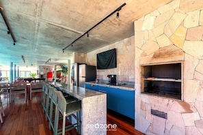 A spacious bar area with a stone wall oven and a long counter. - Apt. w/ Balcony in Condo. w/ Pool Vat0002 (Camaçari)