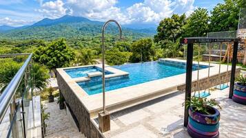Piscina rectangular al aire libre con hidromasaje integrado, rodeada de escalones de piedra y plantas en macetas.