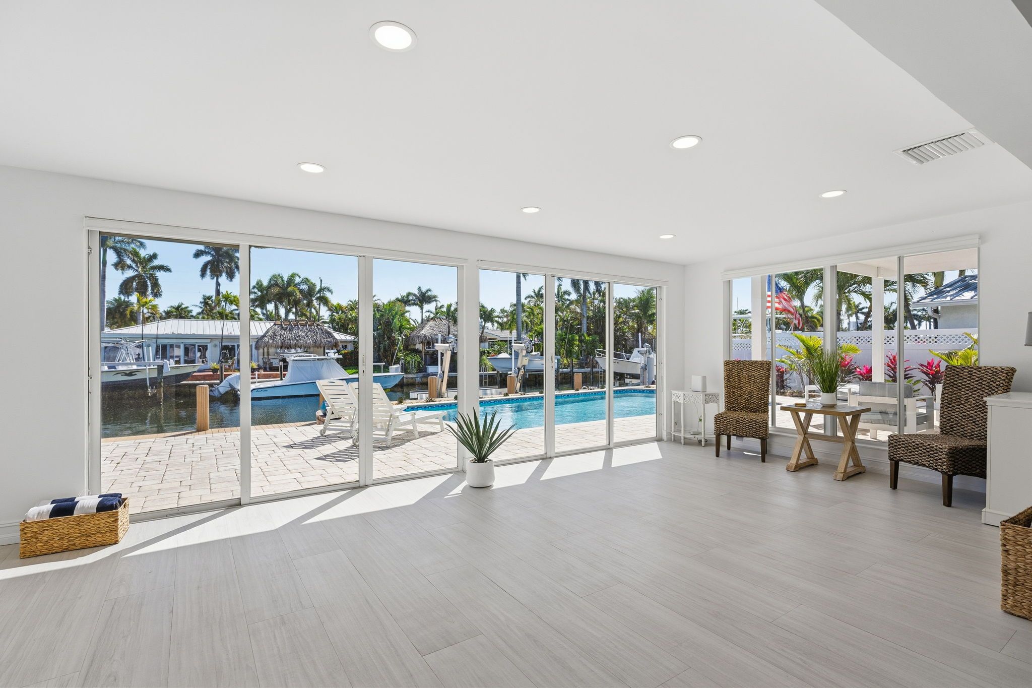 A spacious room with large windows, a pool, and outdoor seating.