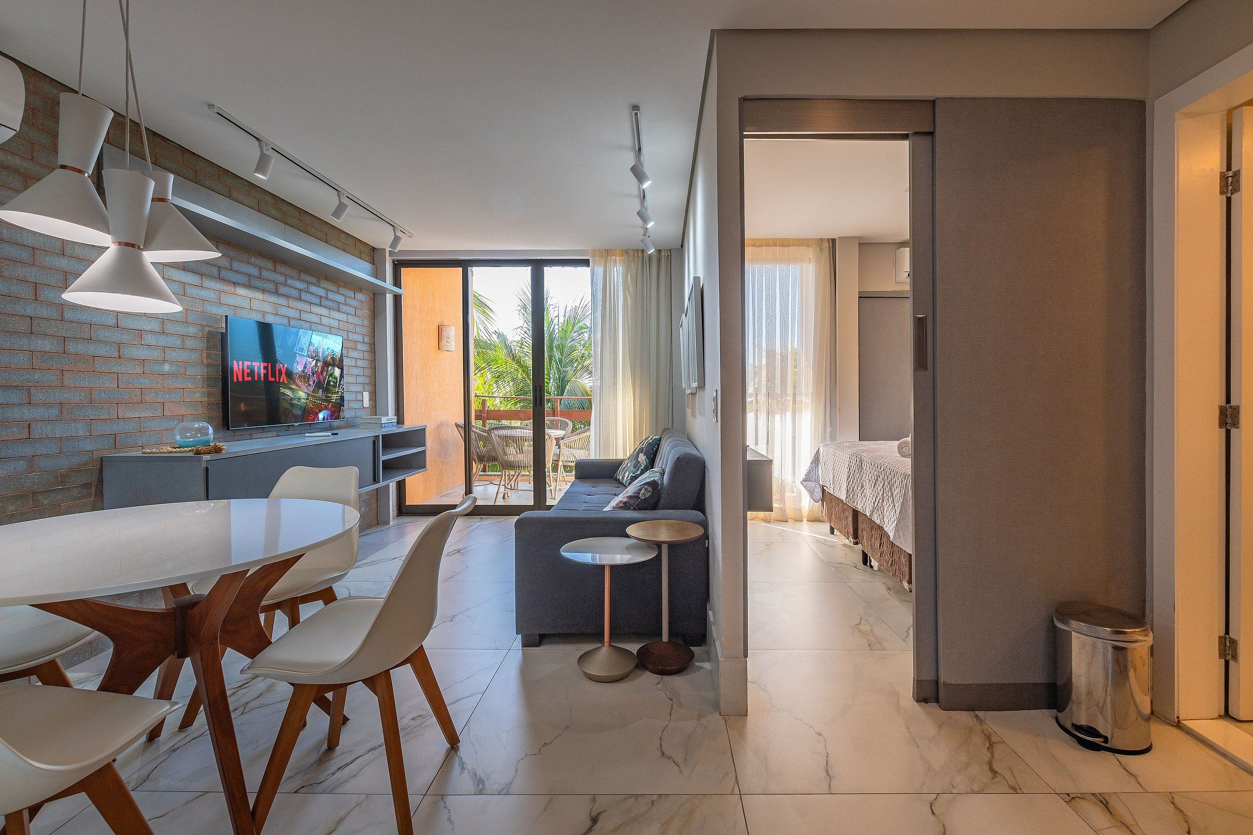 Un espace de vie moderne comprenant une cuisine, un coin repas et une chambre.