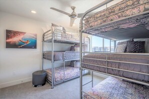 A bunk bed room with a ceiling fan, a window, and a painting on the wall. - Spacious 5bedroom house in St. George w Access for 8 people to Las Palmas resort (St. George)