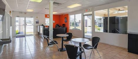 A clean, modern interior with a reception desk, seating area, and large windows.