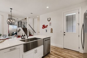 A modern kitchen with a stainless steel sink, a built-in oven, and a wooden floor. - Bold, Colorful Austin Retreat, Sleeps 9, Mins to Downtown, UT & Moody Center (Austin)