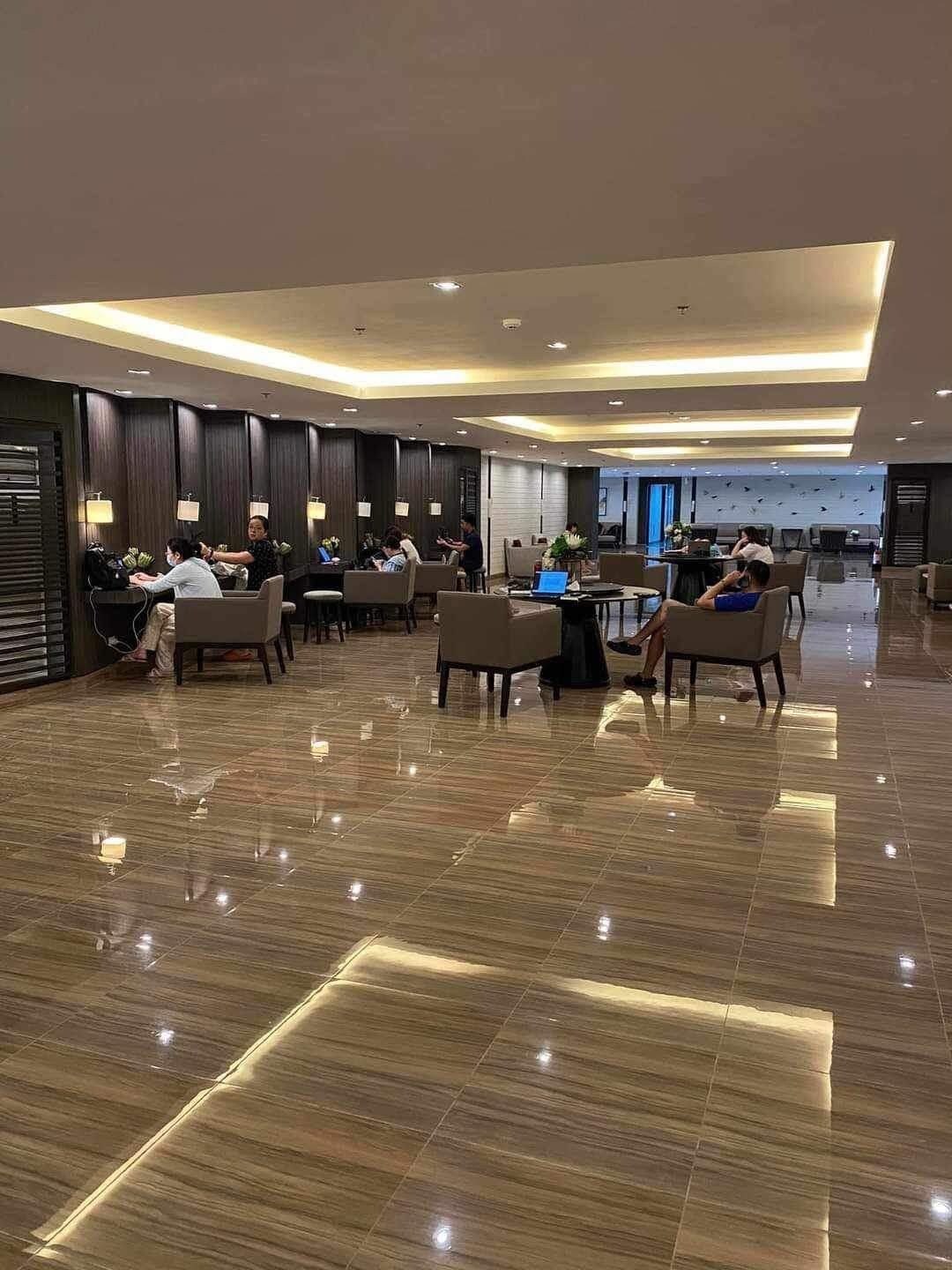 A spacious lobby with a polished floor, seating areas, and a reception desk.