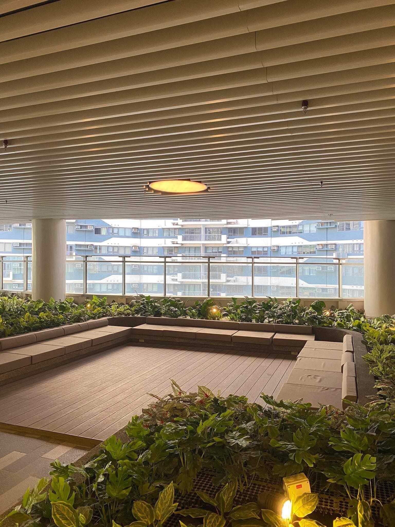 An indoor garden area with a seating area, a water feature, and a view of a residential building.