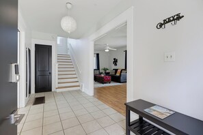 Ein modernes Interieur mit einer Treppe zu einem Wohnbereich, einer schwarzen Tür und einem an der Wand befestigten Schild.