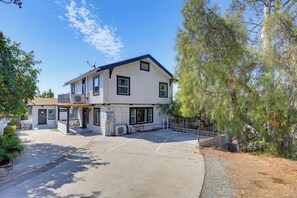 A two-story house with a covered porch and a garage. - Walk to Little Italy | 4BR | Sleeps 8 (San Diego)