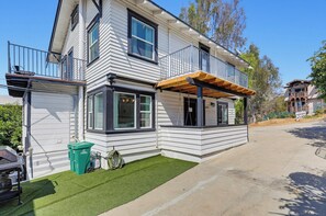 A two-story house with a covered porch and a small front yard. - Walk to Little Italy | 4BR | Sleeps 8 (San Diego)