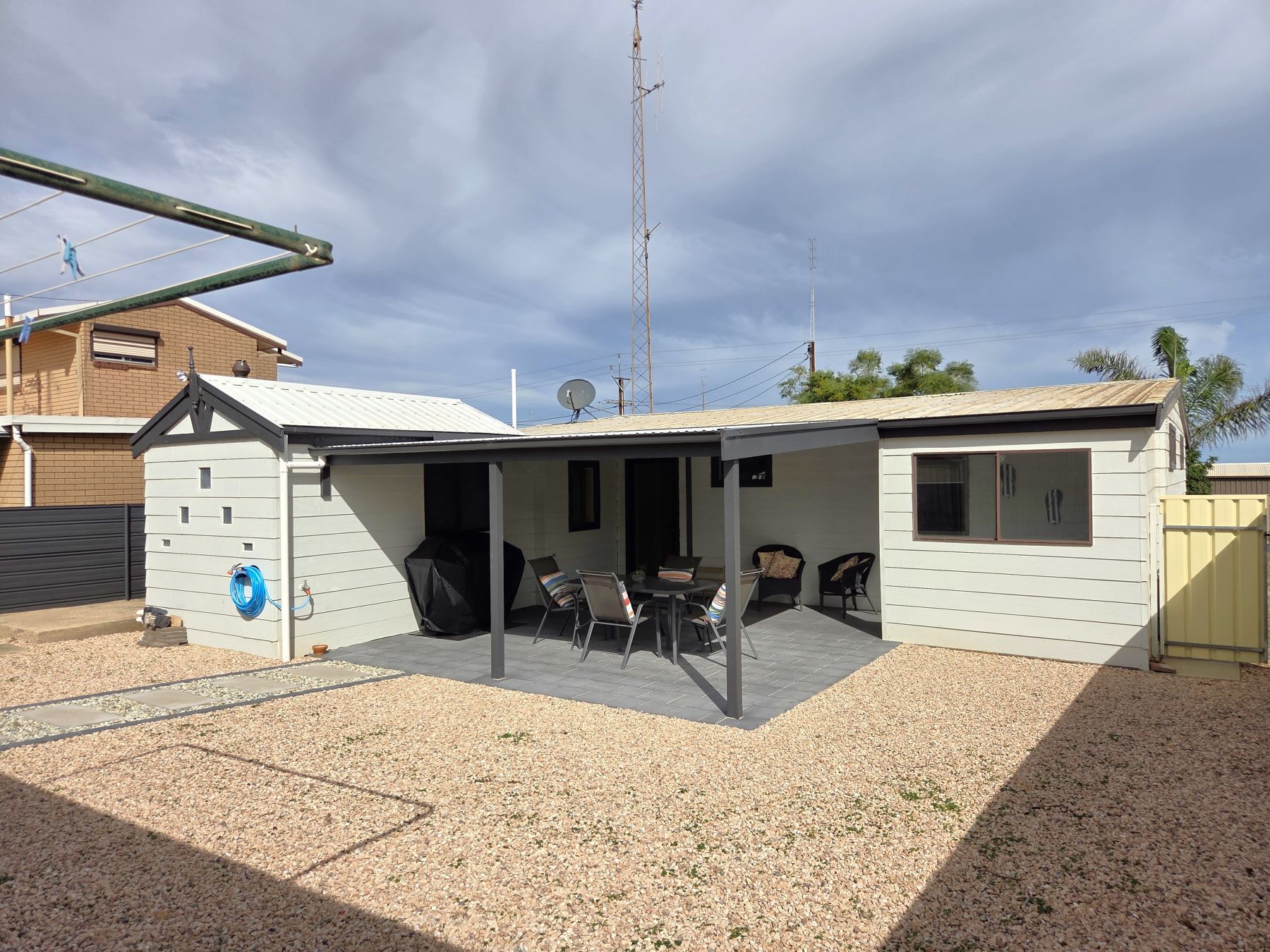 Il s’agit d’une propriété résidentielle dotée d’un patio couvert, d’un espace salon extérieur et d’une antenne parabolique.