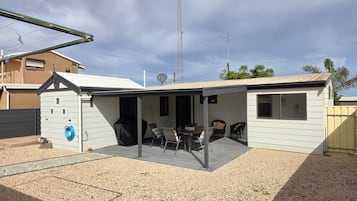 Il s’agit d’une propriété résidentielle dotée d’un patio couvert, d’un espace salon extérieur et d’une antenne parabolique.