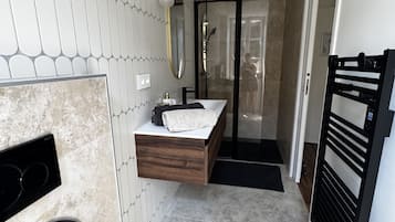 A modern bathroom with a built-in shower, a vanity with a mirror, and a toilet.