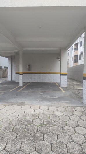 An empty parking area with a tiled floor and a low ceiling. - Modern and Cozy Apartment 200 Meters from Praia Ingleses in Florianópolis (Florianópolis)