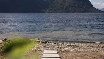 Un sentier qui mène à un plan d’eau, avec une montagne en arrière-plan.