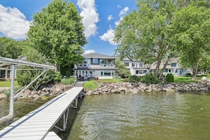 A residential area with a dock leading to a house with a large front yard and a pond. - Luxury Lakeside Oasis- 4 Bed / 3 Bath Lake Home (Middleton)