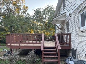 A wooden deck with a staircase leading to a house with a brick exterior. - Perfect place to stay in Duluth,
.5 mi from I-85 walking distance to golf course (Duluth)