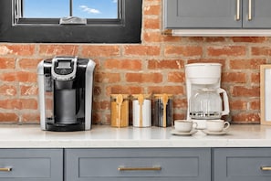 A kitchen with a coffee maker, a coffee pot, and a window above the counter. - Rooftop skyline views, walkable WeHo house, sleeps 10 near Geodis Park (Nashville)