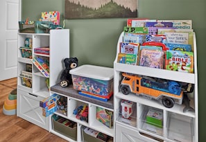 A children's bookshelf with various educational books and toys. - Wineberry Ridge | Hot Tub • Sauna • Grill • Views (Asheville)