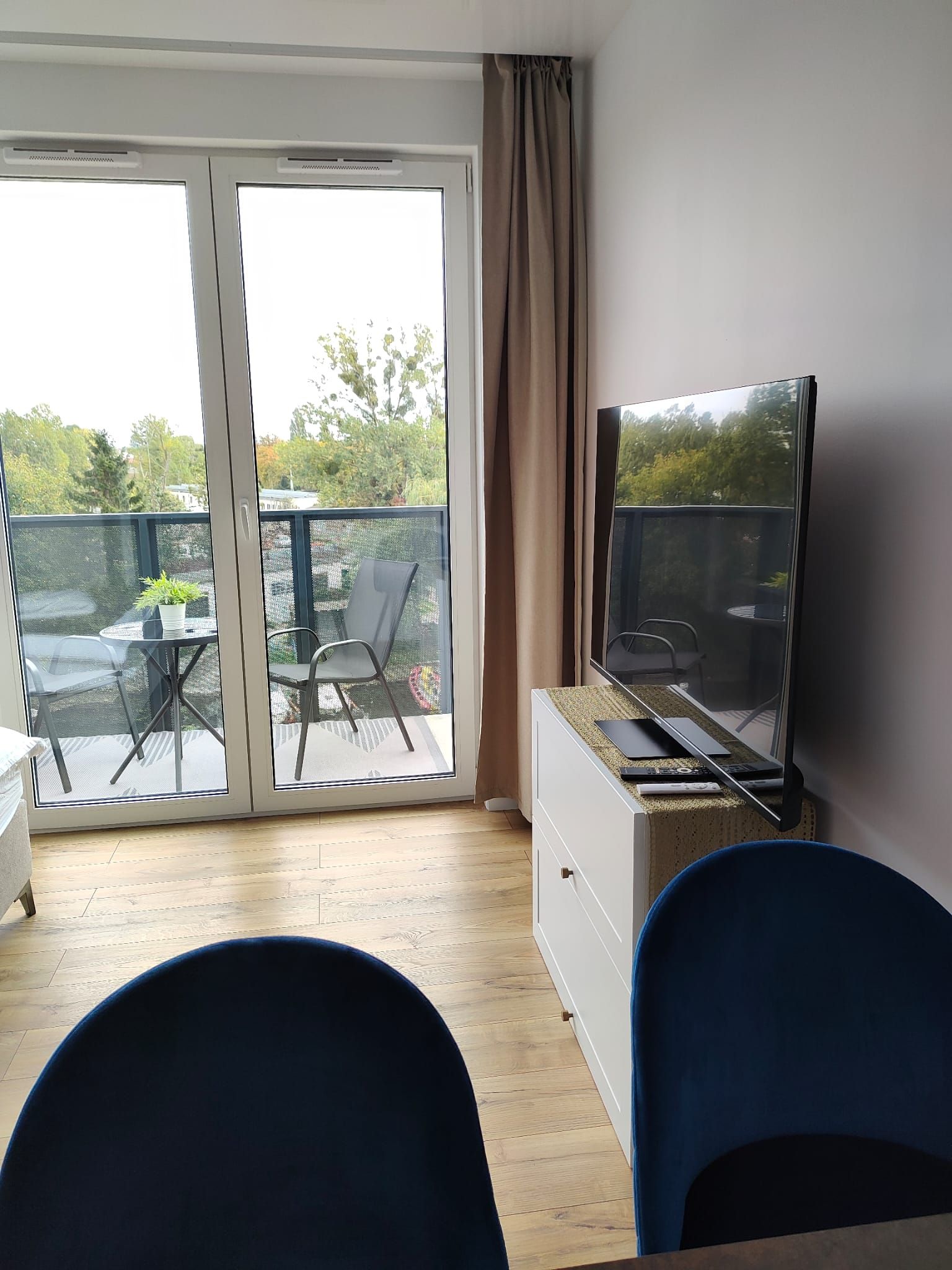 A room with a sliding glass door leading to an outdoor area with a table and chairs.