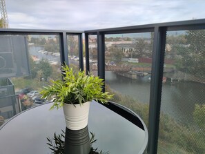 A balcony with a round table and a potted plant. - LILY APART River View & FREE PARKING (Gdańsk)
