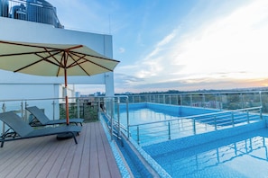 A rooftop pool area with lounge chairs and an umbrella. - Serene One Bedroom Apartment at the heart of Westlands, Kenya (Nairobi)