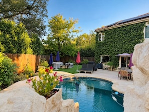 A backyard with a swimming pool, covered seating, and a wooden fence. - Agoura Hills Retreat - Malibu Beaches and Mountain Trails (Agoura Hills)