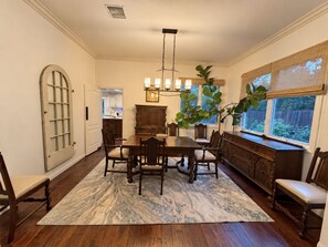 A dining room with a marble-patterned rug, wooden dining table, chairs, and a chandelier. - Agoura Hills Retreat - Malibu Beaches and Mountain Trails (Agoura Hills)