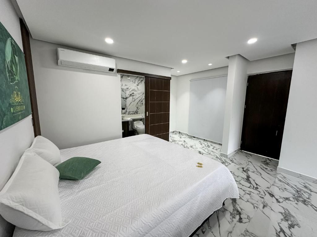 Ein modernes Schlafzimmer mit Bett, Kleiderschrank und Bad.