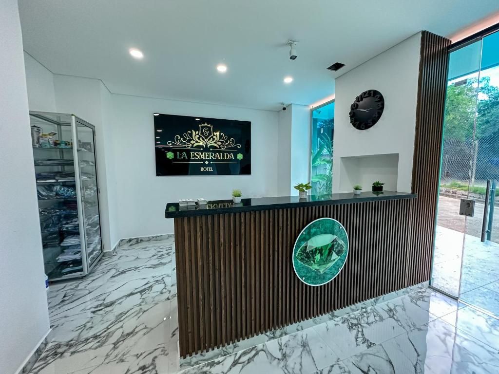 Ein Hotelrezeptionstresen mit einer digitalen Anzeige, einer Uhr und einer Glastür zum Außenbereich.