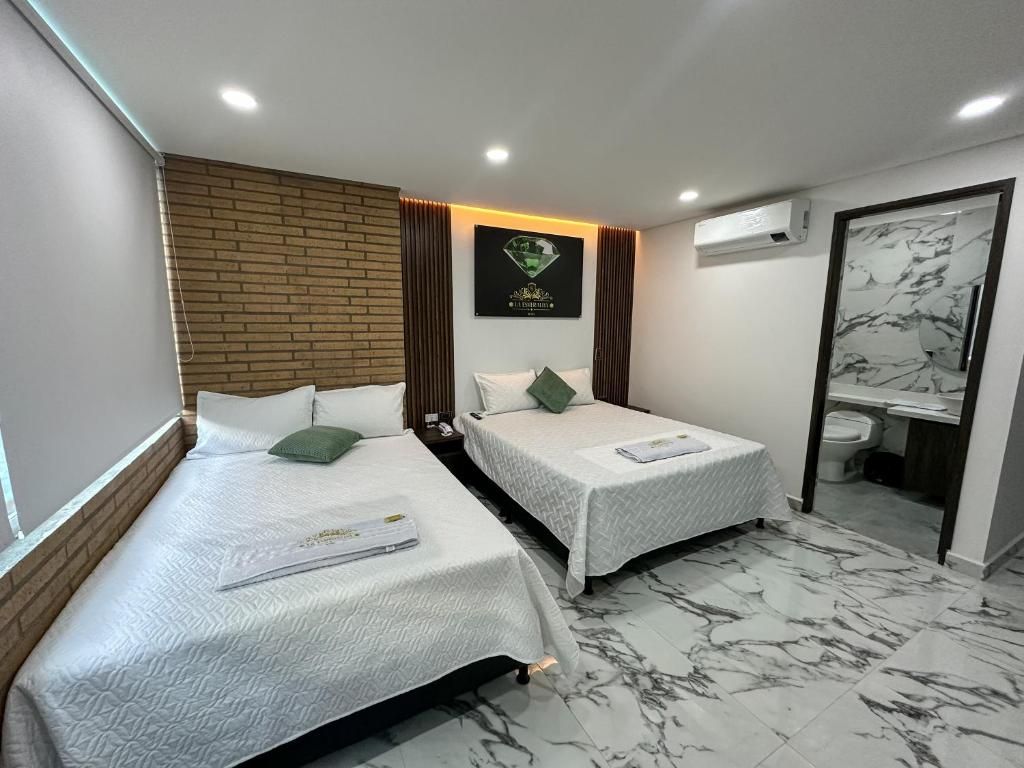 A hotel room with two beds, a bathroom, and a marble floor.