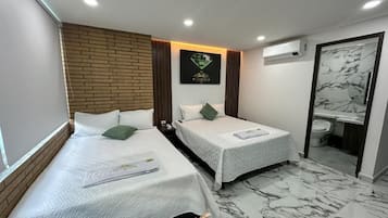 A hotel room with two beds, a bathroom, and a marble floor.
