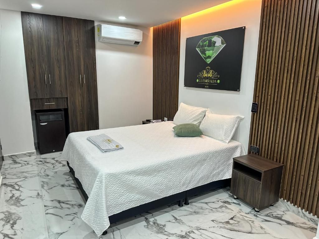 A hotel room with a bed, a nightstand, a wardrobe, and a wall-mounted air conditioner.